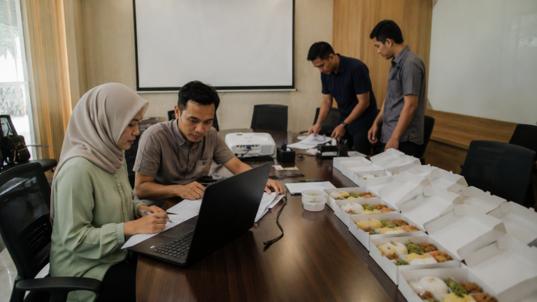 Panitia menghitung nasi kotak untuk konsumsi rapat kantor